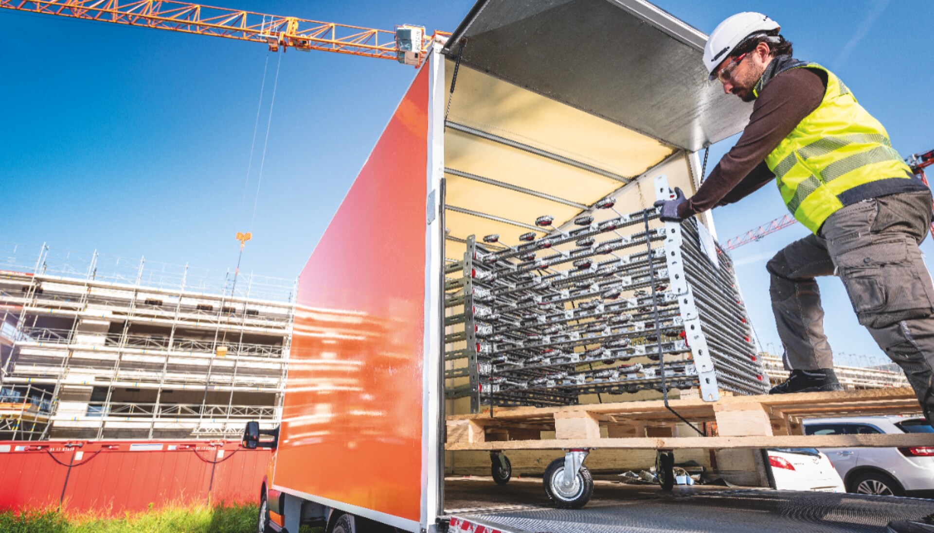 Worker unloading prefabricated modular support modules from a truck